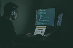 Person working on cybersecurity code at a computer.