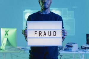 A man holding up a sign with the word fraud on it